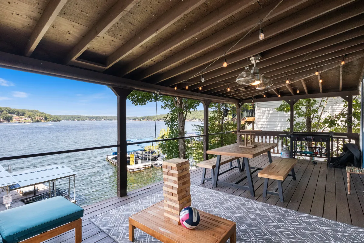 This image captures an outdoor seating area overlooking the lake, with a Jenga game set up and a volleyball nearby. The setting is casual and inviting, framed by the lake and surrounding trees, and highlights the opportunity for social gatherings and fun group activities in a waterfront environment.